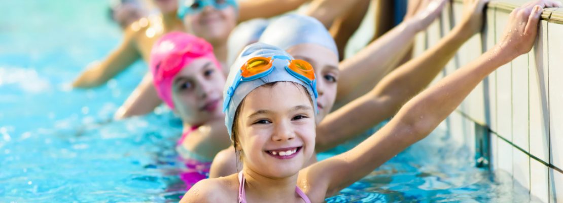 kinder-am-beckenrand-im-schwimmbecken-machen-ihr-seepferdchen