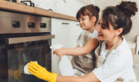 Mutter und Kind räumen gemeinsam auf und haben Spaß
